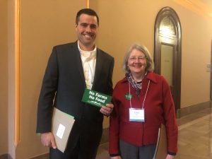 Land trust staff and farmer pose with No Farms No Food bumper sticker in New York State Capitol.