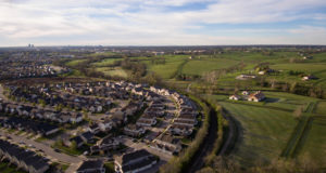 photo graph of a "Smart Growth Boundary" in Kentucky. Image shows housing development abutting farmland that is protected by the boundary. 