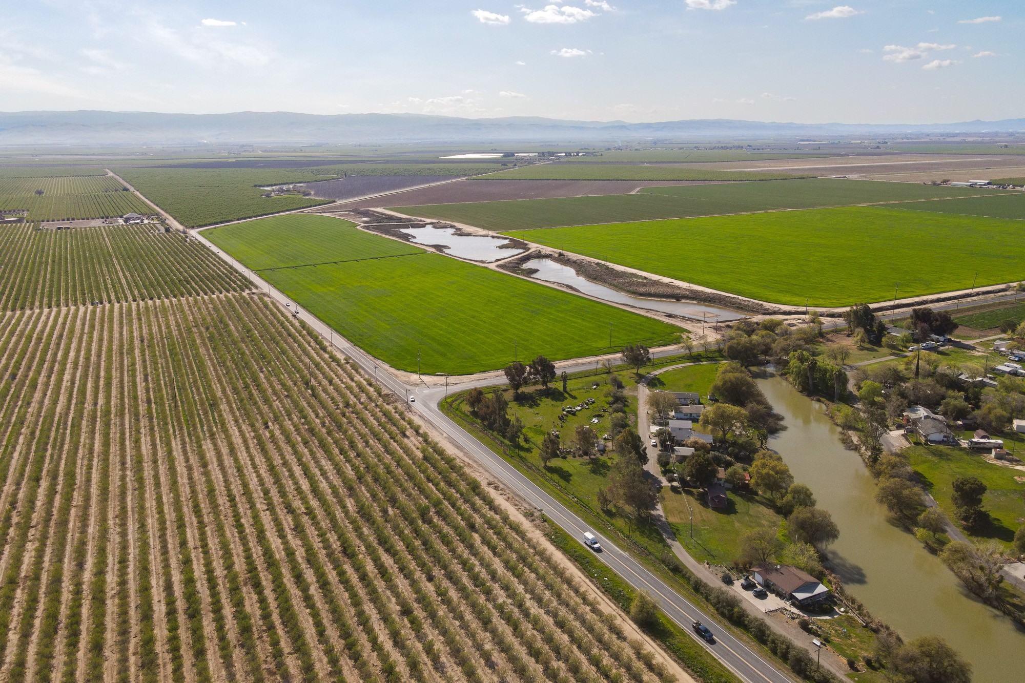 drone shot of San Joaquin Valley orchard houses and river